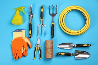 Flat lay composition with gardening tools on light blue background