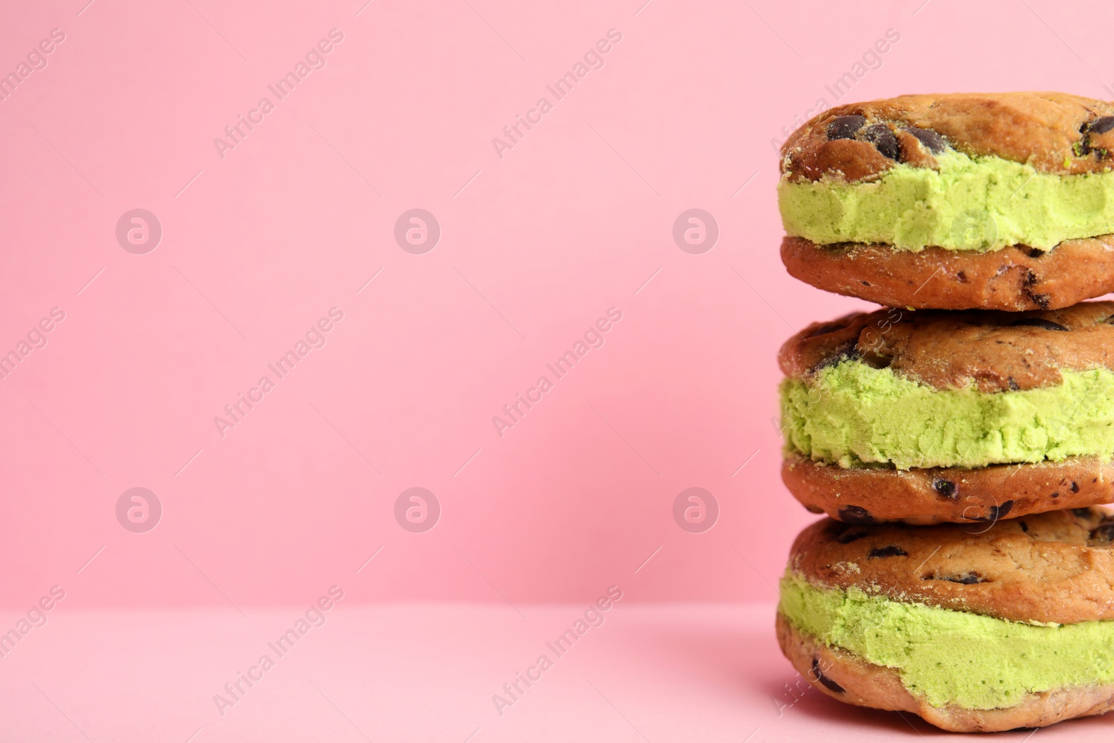 Photo of Sweet delicious ice cream cookie sandwiches on color background, space for text