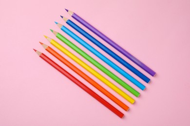 Colorful wooden pencils on pink background, flat lay