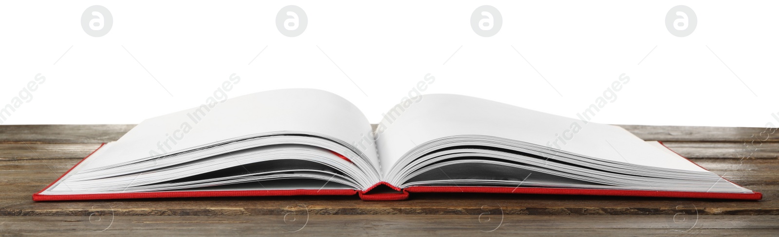 Photo of Open book with red cover on wooden table against white background