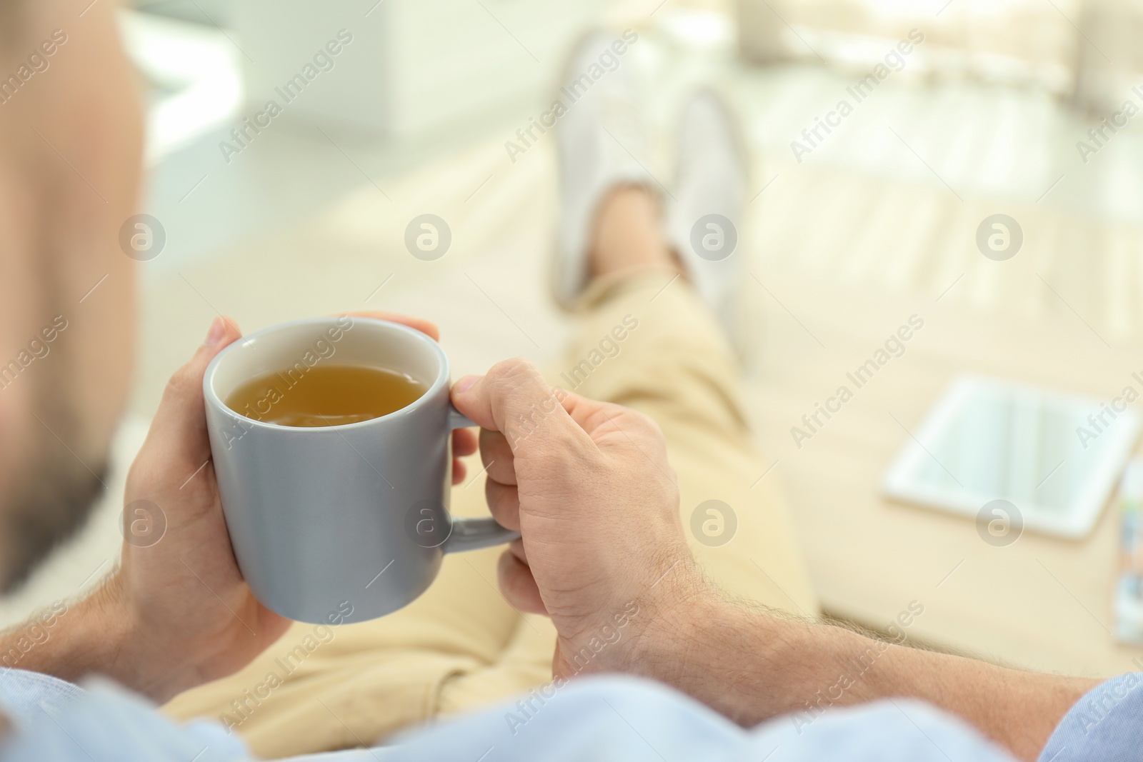 Photo of Man with cup of hot tea relaxing at home, closeup. Space for text