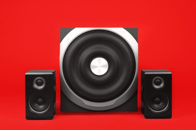 Photo of Modern powerful audio speaker system on red background