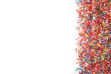 Photo of Colorful sprinkles on white background, top view. Confectionery decor