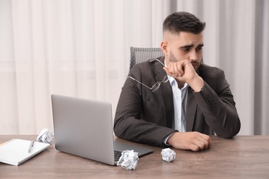 Photo of Sad businessman sitting at table in office