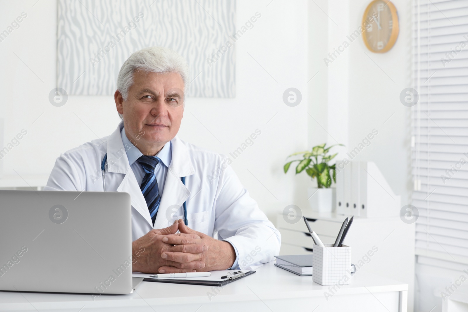 Photo of Portrait of senior doctor in white coat at workplace