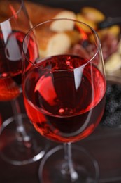 Photo of Glasses of delicious rose wine on table, closeup