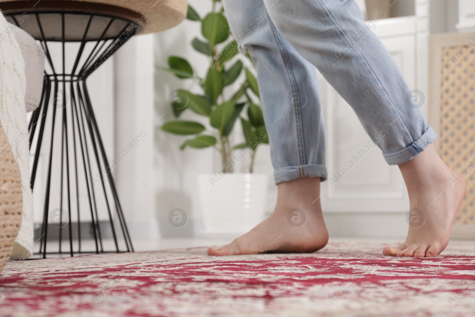 Photo of Woman standing on carpet with pattern at home, closeup. Space for text