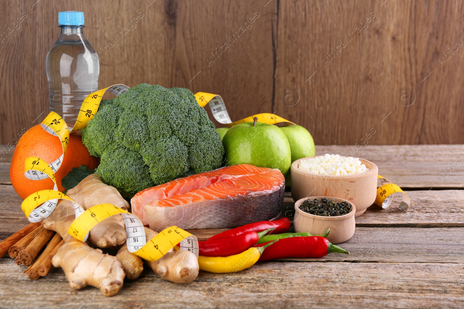 Photo of Metabolism. Different food products and measuring tape on wooden table