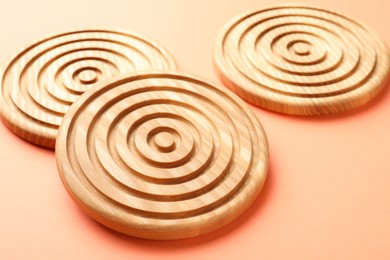 Stylish wooden cup coasters on orange background