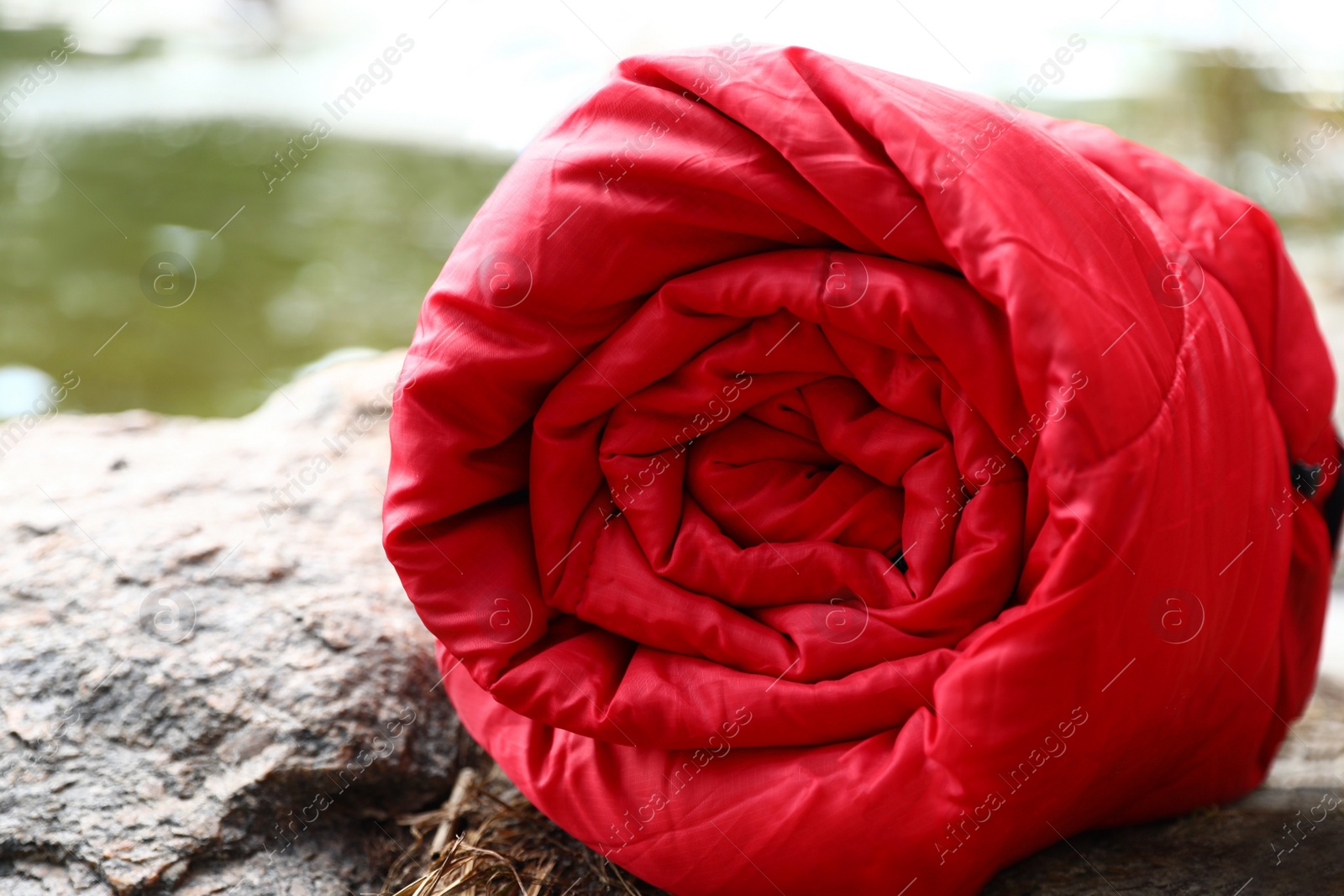 Photo of Rolled sleeping bag outdoors on sunny day, closeup