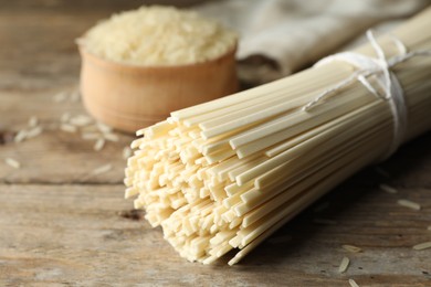 Raw rice noodles on wooden table, closeup