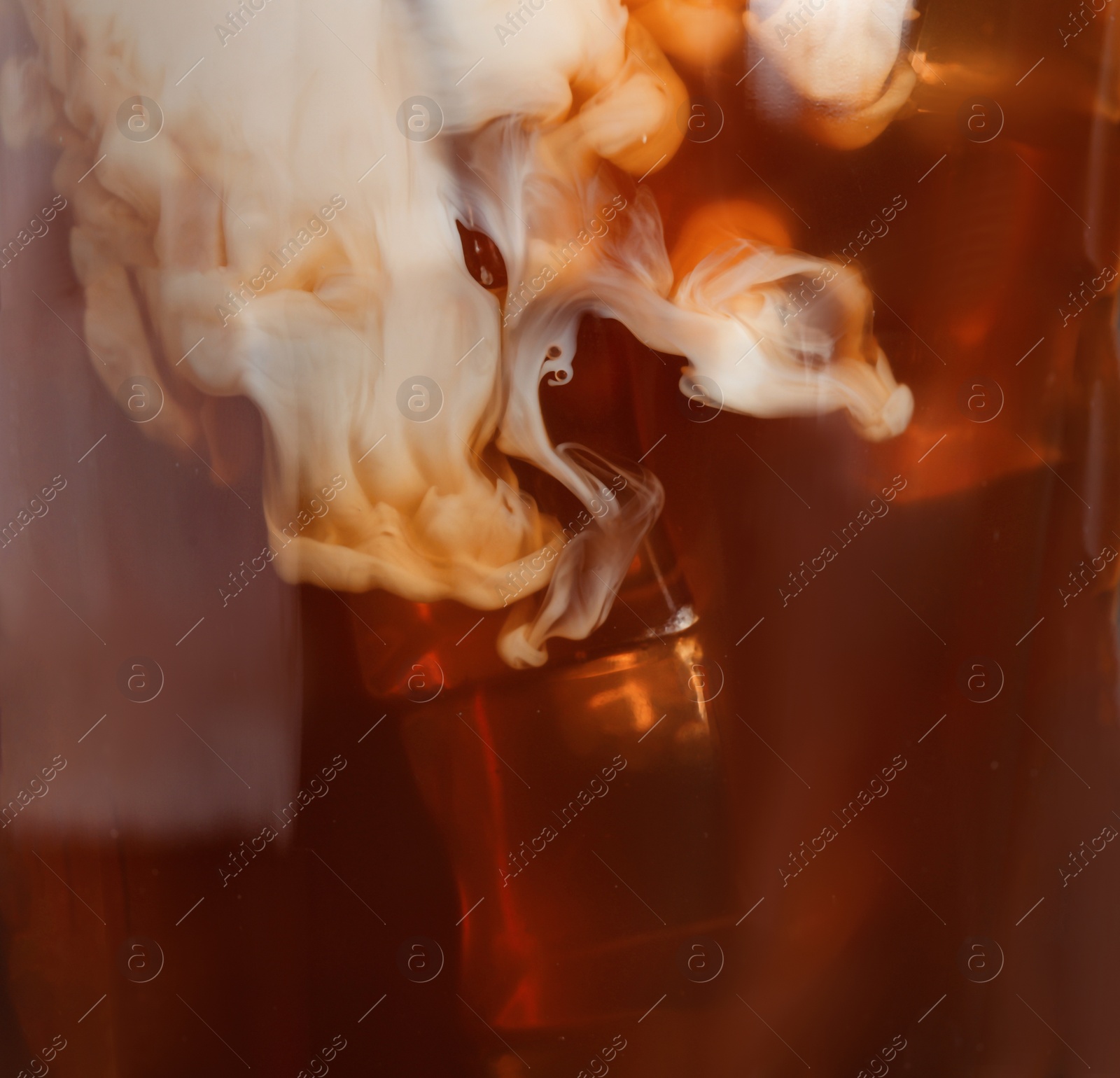 Photo of Glass with iced coffee and milk, closeup