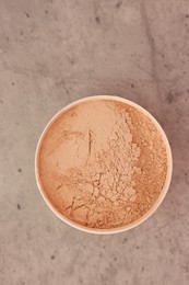 Photo of Face powder on grey textured table, top view