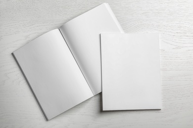 Photo of Open and closed blank brochures on wooden background, top view. Mock up for design