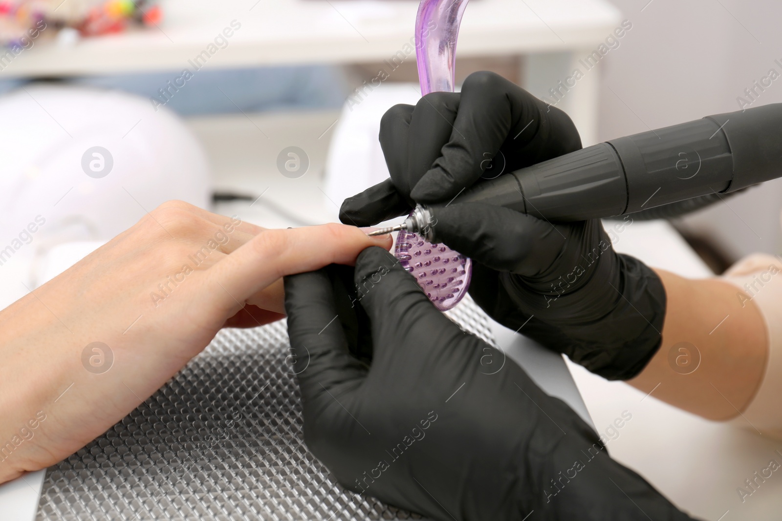 Photo of Professional manicurist working with client, closeup view