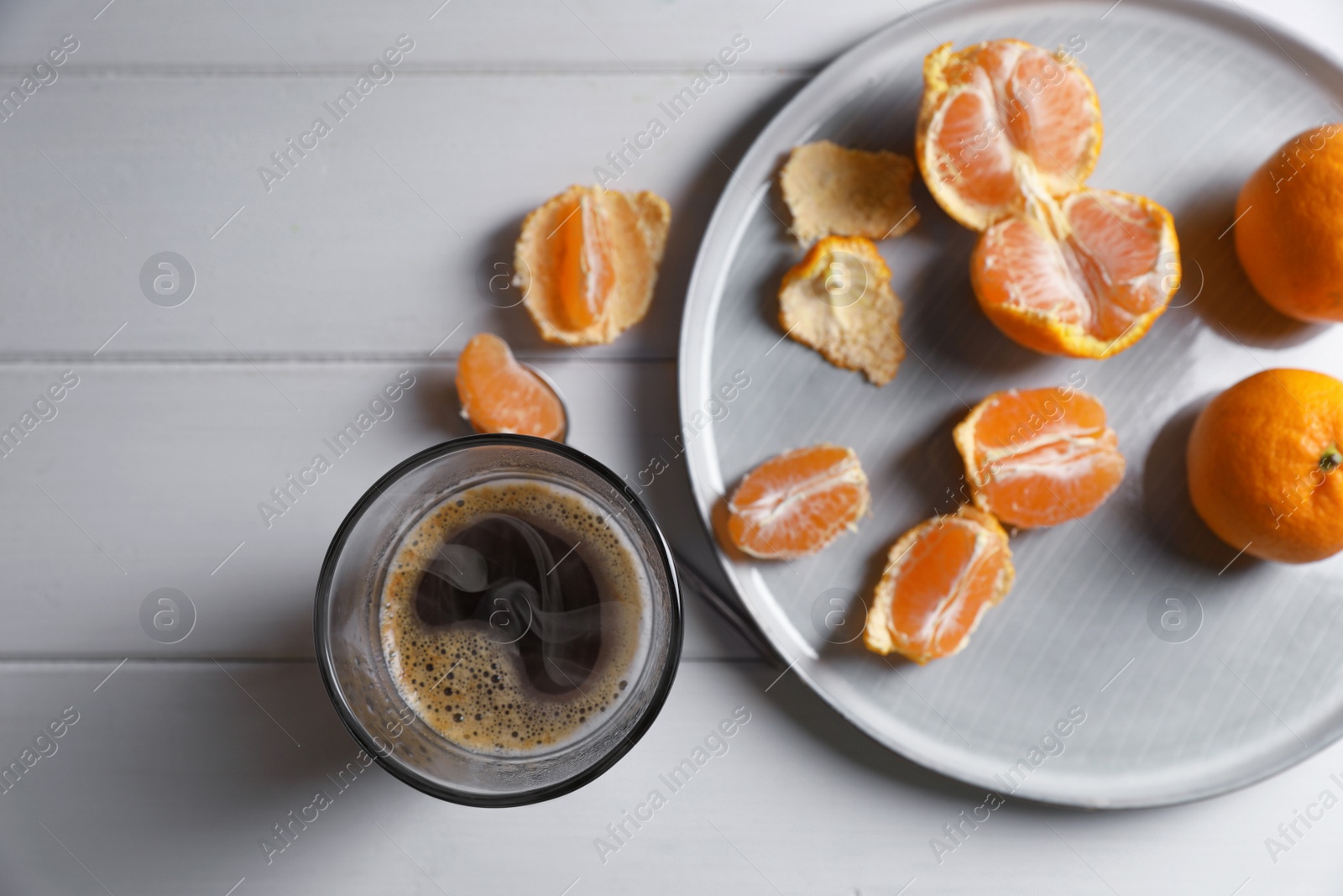 Photo of Fresh ripe tangerines and cup of coffee on white wooden table, flat lay