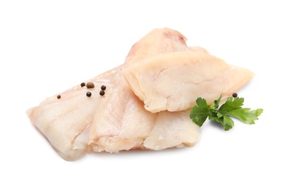 Pieces of raw cod fish, parsley and peppercorns isolated on white