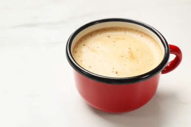 Cup of aromatic coffee on white table, closeup. Space for text