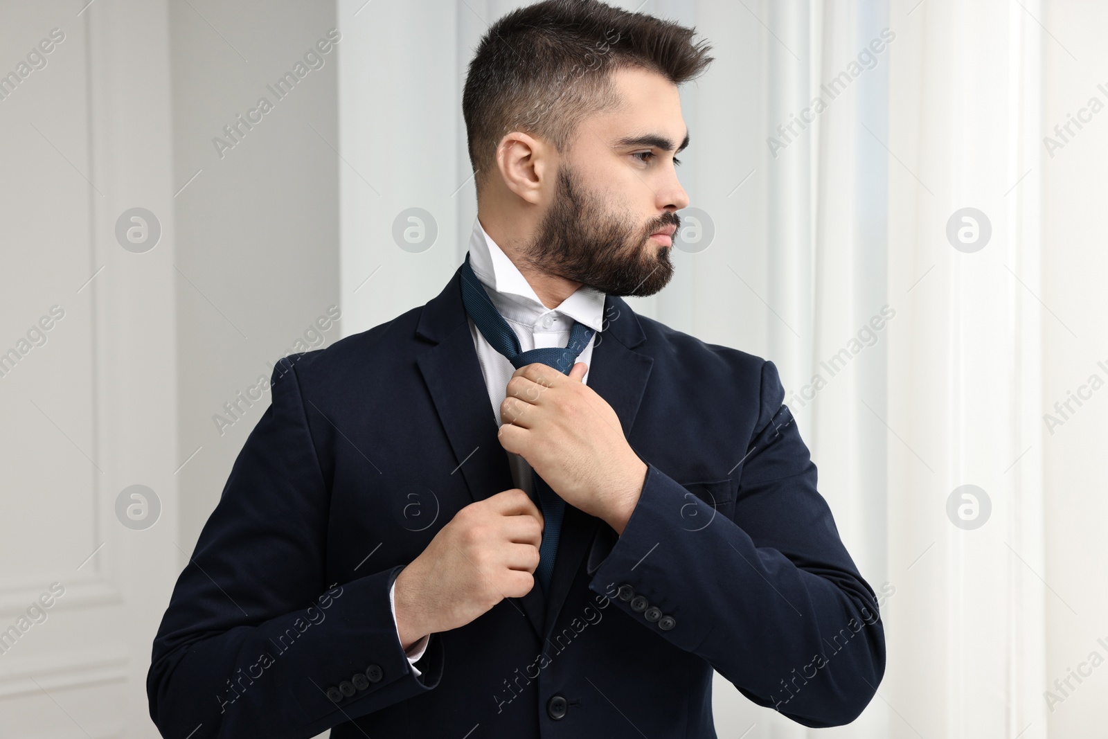 Photo of Handsome businessman in suit and necktie indoors