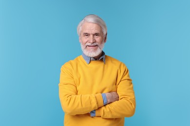 Portrait of stylish grandpa on light blue background