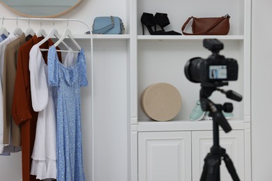 Fashion blogger's workplace. Shoes, clothes, camera and stylish furniture indoors