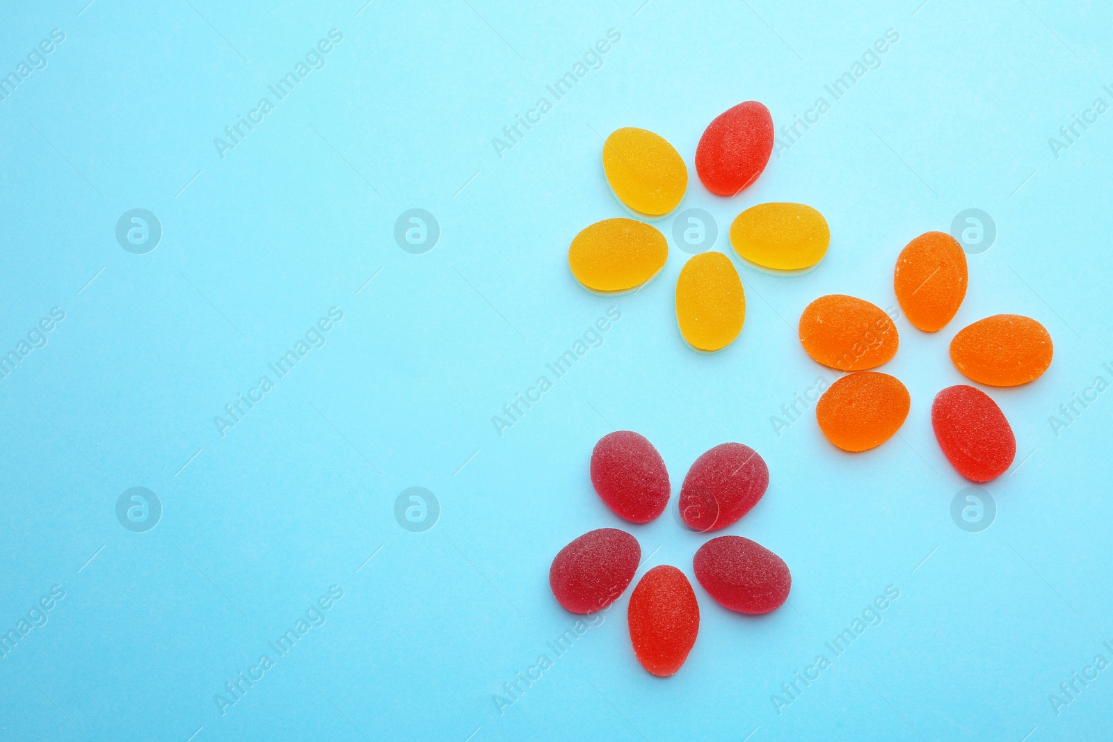 Photo of Flat lay composition with tasty jelly candies and space for text on color background