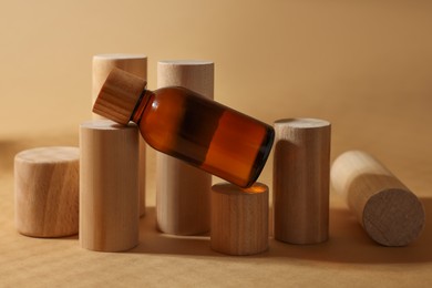 Composition with glass bottle of cosmetic product on dark beige background