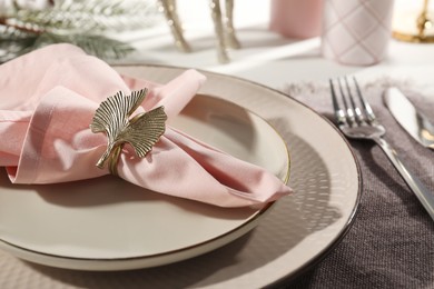 Photo of Stylish table setting with pink fabric napkin, beautiful decorative ring and festive decor on white background, closeup