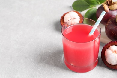 Photo of Delicious mangosteen juice in glass on light table. Space for text