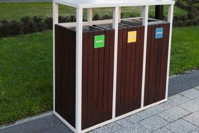 Photo of Different sorting bins for waste recycling outdoors