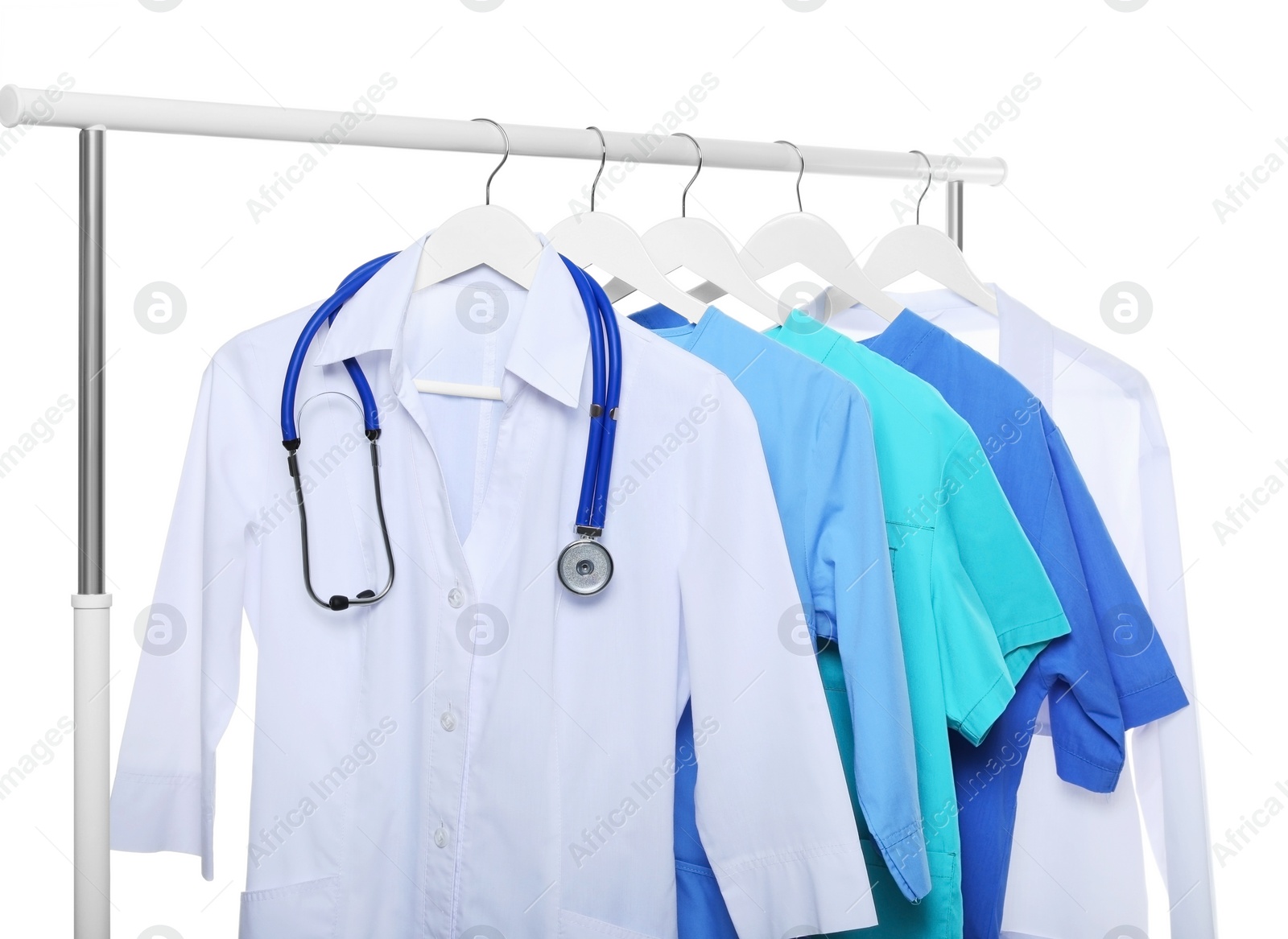 Photo of Doctor's gown with stethoscope and different medical uniforms on rack against white background