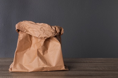 Photo of Paper bag on table against dark background. Space for text