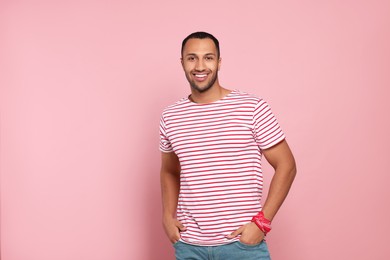 Portrait of happy African American man on pink background. Space for text