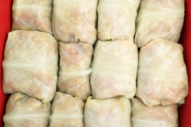 Stuffed cabbage rolls in baking dish as background, top view