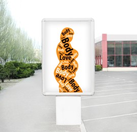 Signboard with orange silhouette of plus-size model with words Body Love on city street