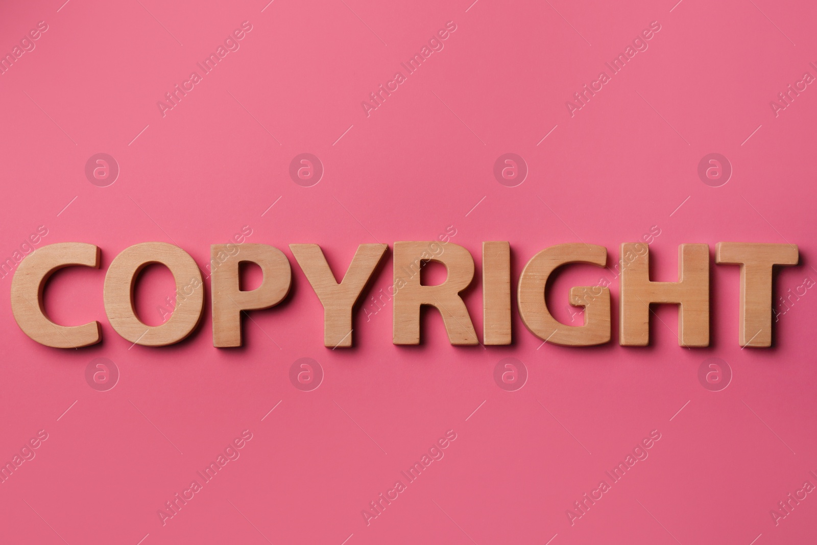 Photo of Word Copyright made of wooden letters on dark pink background, flat lay. Plagiarism concept