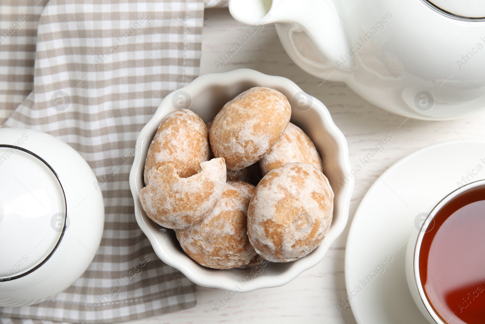 Photo of Tasty homemade gingerbread cookies and tea on white wooden table, flat lay