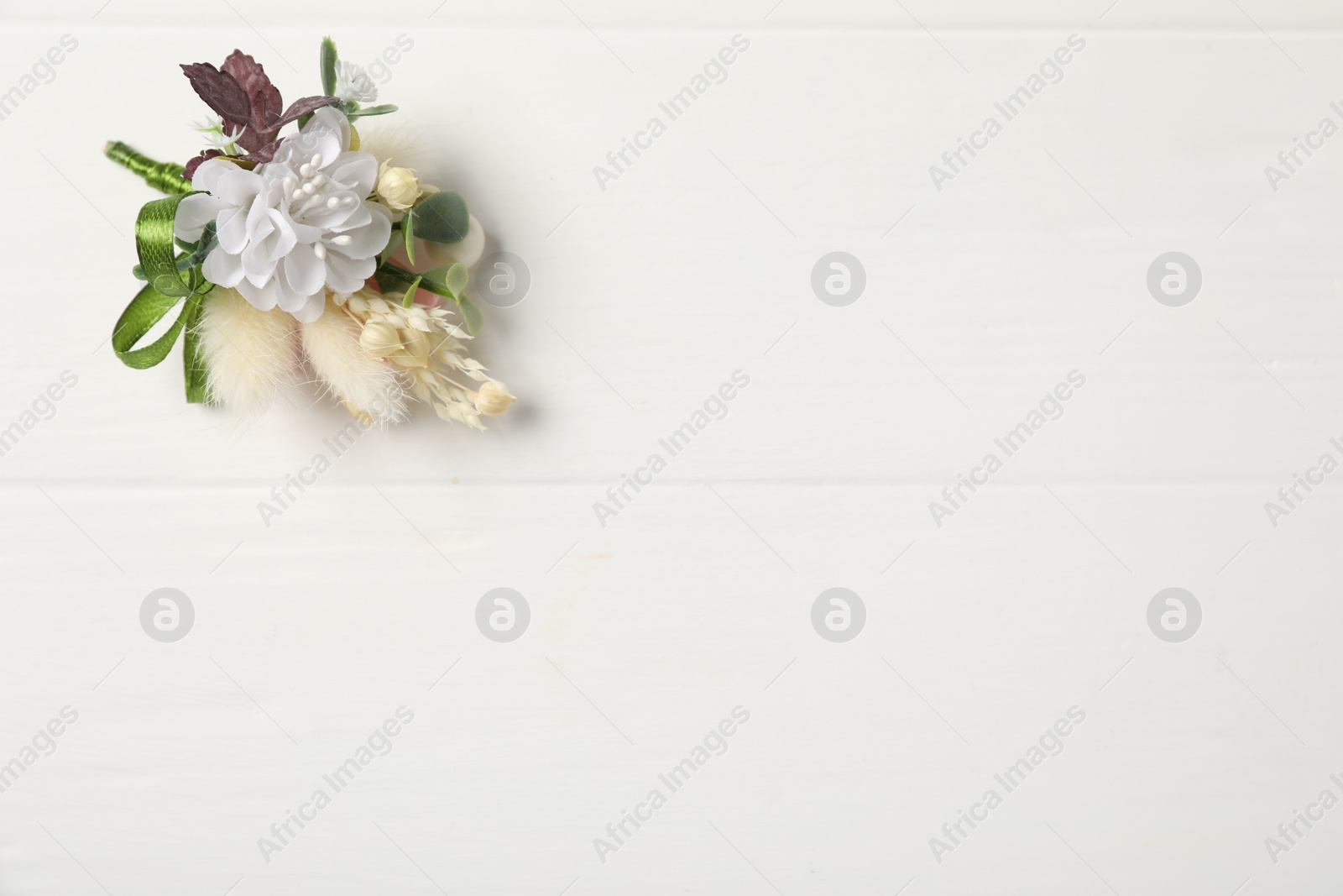 Photo of Beautiful boutonniere on white background, top view. Space for text