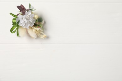 Photo of Beautiful boutonniere on white background, top view. Space for text