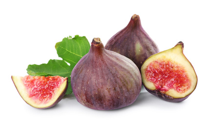 Photo of Tasty whole and cut figs with green leaf isolated on white