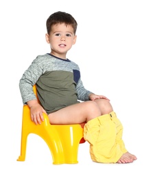 Photo of Portrait of little boy sitting on potty against white background