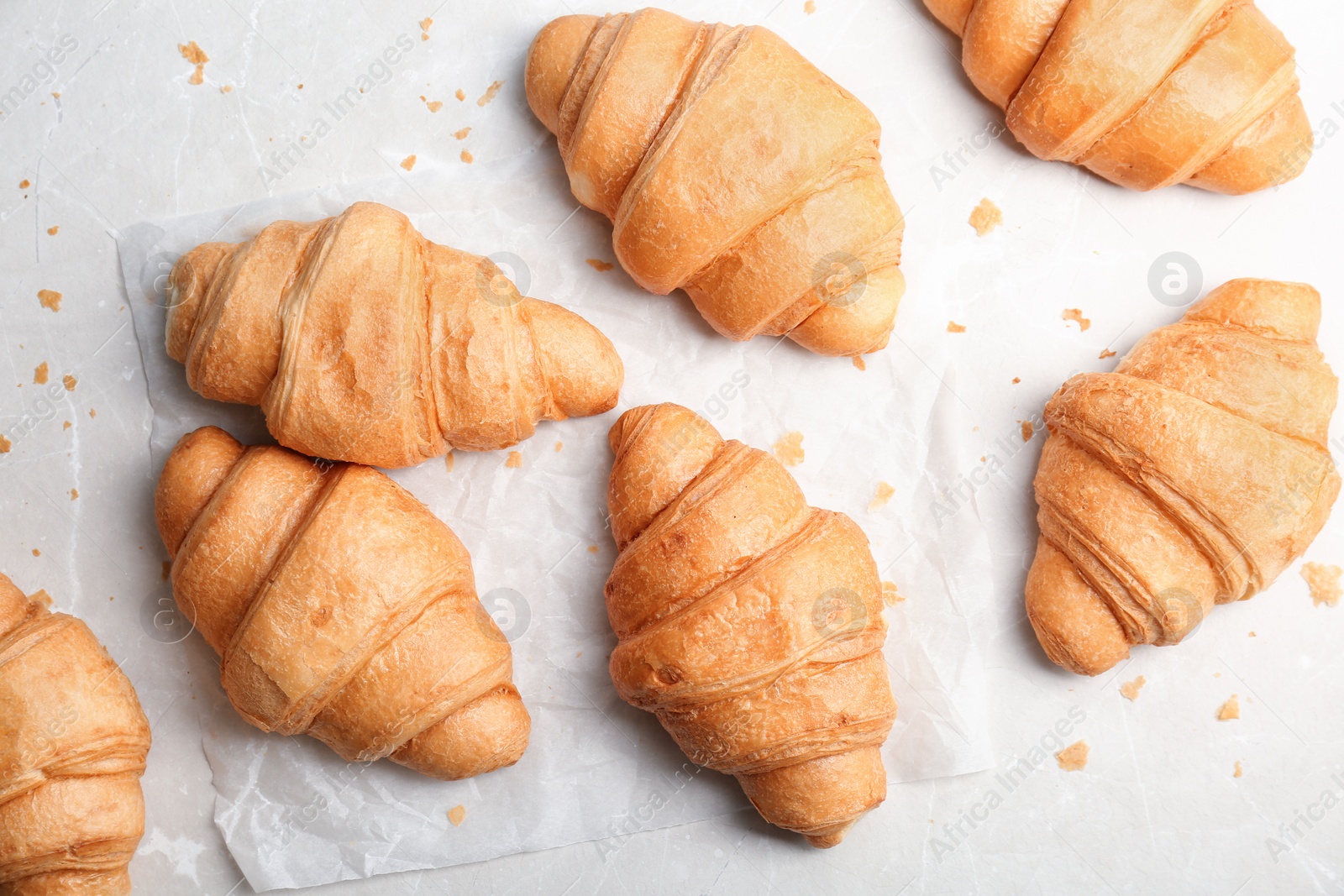 Photo of Tasty croissants on light background, top view