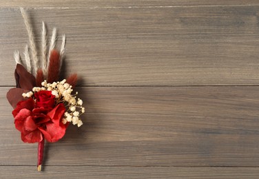 Beautiful boutonniere on wooden background, top view. Space for text