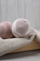 Photo of Bath bombs in crate on wooden table, closeup