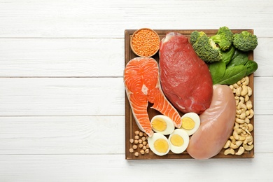 Photo of Set of natural food high in protein and space for text on wooden background, top view