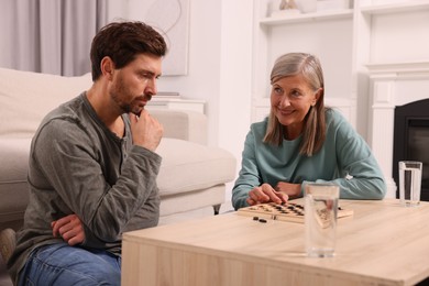 Family playing checkers at coffee table in room