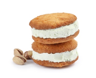 Photo of Sweet delicious ice cream cookie sandwiches and pistachios on white background