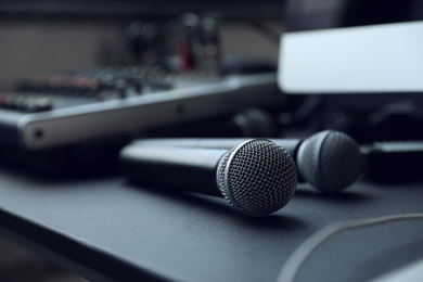 Photo of Modern microphone on black table indoors, closeup