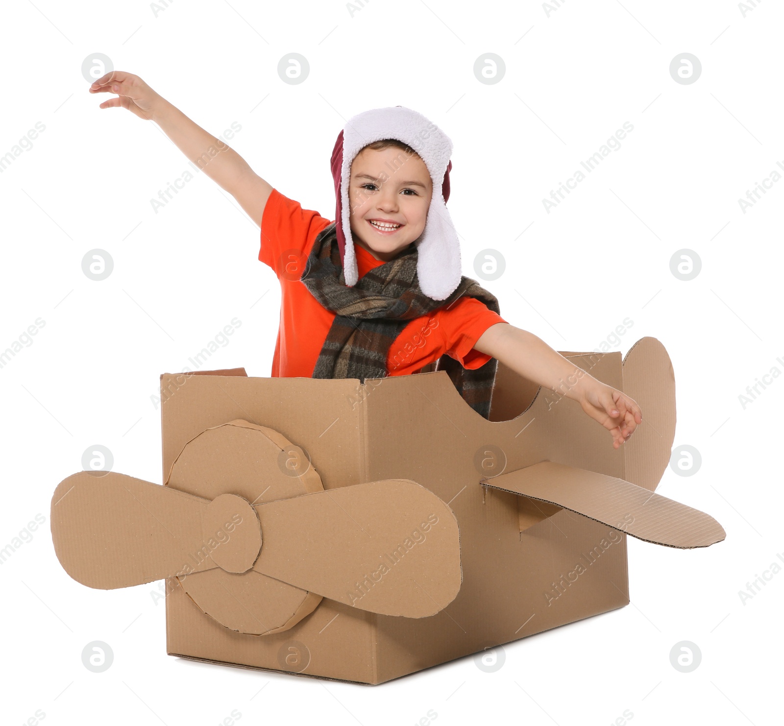 Photo of Cute little boy playing with cardboard airplane on white background