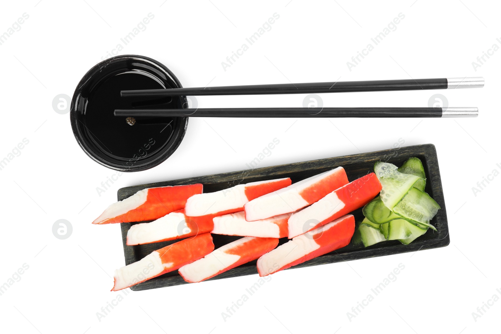 Photo of Fresh crab sticks with soy sauce and cucumber on white background, top view